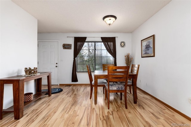 dining room with baseboards and light wood-style flooring