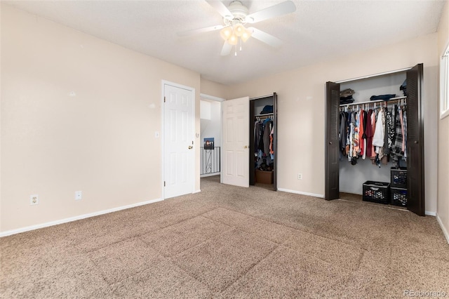 unfurnished bedroom featuring two closets, baseboards, carpet floors, and ceiling fan