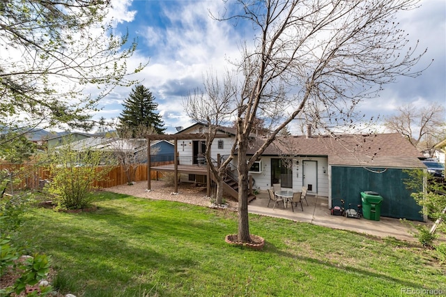 back of house featuring fence, a wooden deck, a patio, stairs, and a lawn