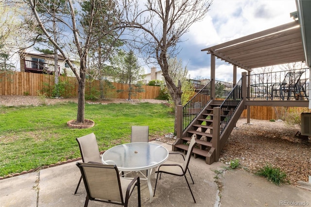view of patio / terrace featuring outdoor dining area, a fenced backyard, and stairway