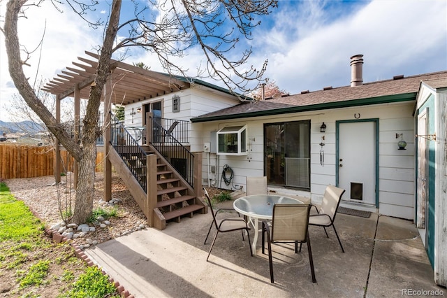 view of patio with stairs, fence, a pergola, and outdoor dining space