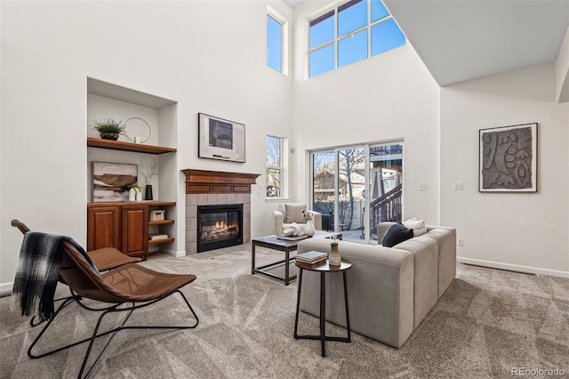 carpeted living room featuring built in features, a fireplace, plenty of natural light, and baseboards