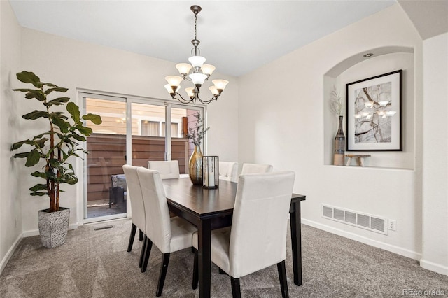 carpeted dining area featuring an inviting chandelier, visible vents, and baseboards