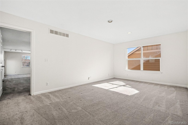 spare room with carpet, visible vents, baseboards, and recessed lighting