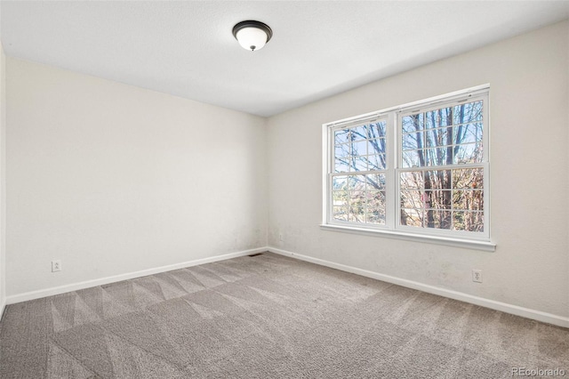 carpeted spare room with baseboards