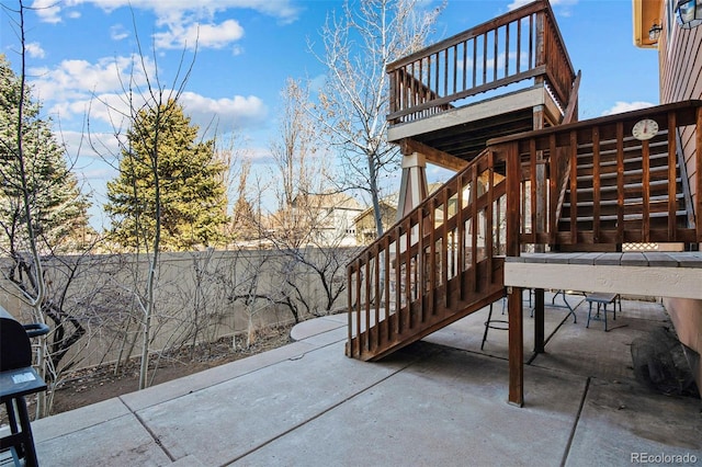 view of patio featuring stairway and fence