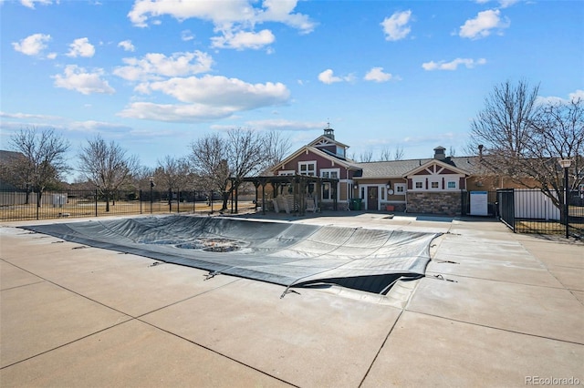 pool with a patio area and fence