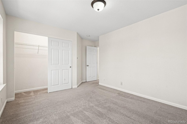 unfurnished bedroom with carpet floors, baseboards, and a closet