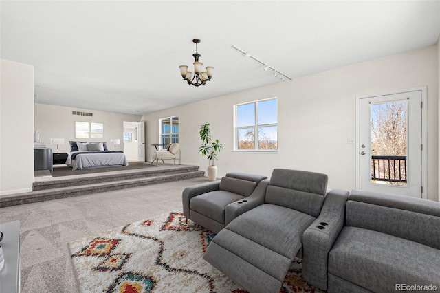 12997 Wyandot Way, Westminster, CO 80234 - carpeted living area with a chandelier, track lighting, and healthy amount of natural light