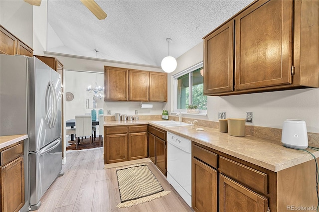 5543 S Kenton Ct, Englewood, CO 80111 - kitchen featuring freestanding refrigerator, dishwasher, a textured ceiling, vaulted ceiling, and brown cabinets
