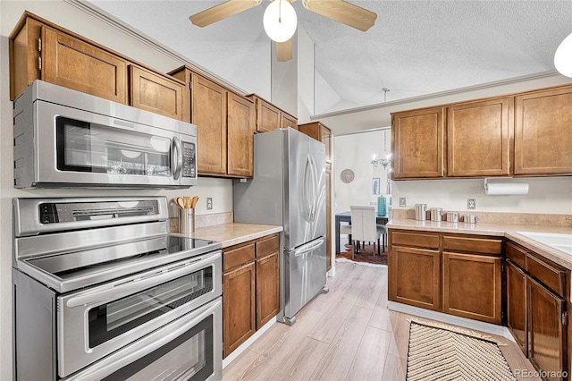 5543 S Kenton Ct, Englewood, CO 80111 - kitchen featuring appliances with stainless steel finishes, lofted ceiling, brown cabinets, light countertops, and a ceiling fan