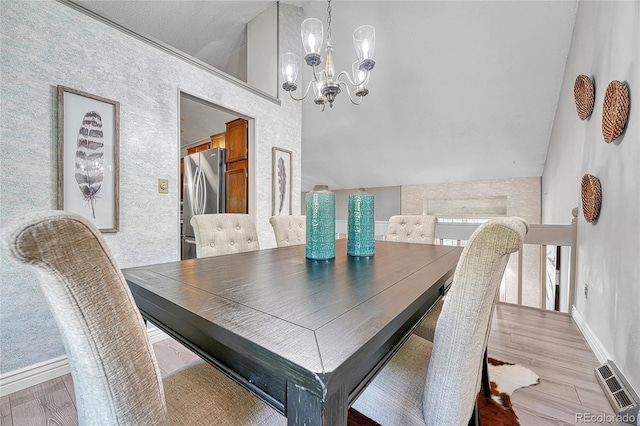 5543 S Kenton Ct, Englewood, CO 80111 - dining area with vaulted ceiling, a chandelier, and light wood-style floors