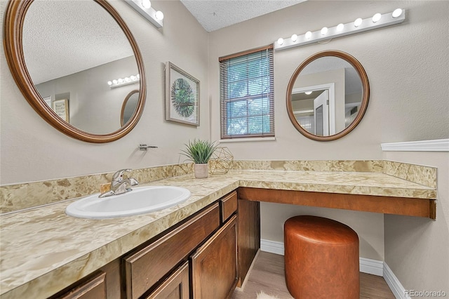 5543 S Kenton Ct, Englewood, CO 80111 - bathroom featuring a textured ceiling, vanity, and wood finished floors