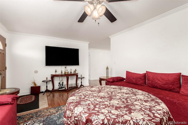 bedroom with ceiling fan, crown molding, and hardwood / wood-style flooring