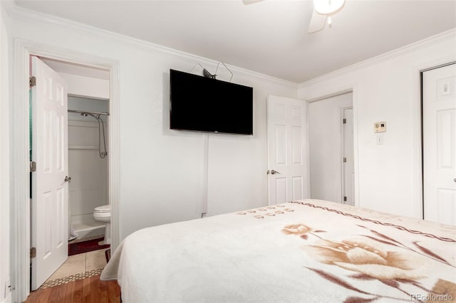 bedroom with crown molding, ensuite bath, hardwood / wood-style flooring, ceiling fan, and a closet