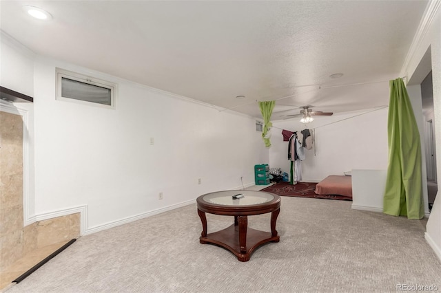 sitting room with a textured ceiling, carpet floors, ceiling fan, and crown molding