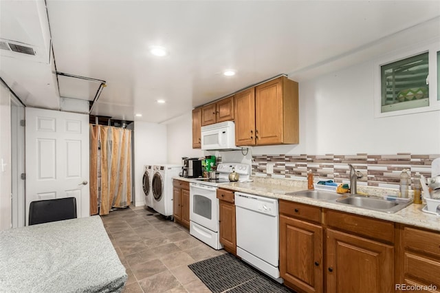 kitchen featuring backsplash, washer and clothes dryer, white appliances, and sink