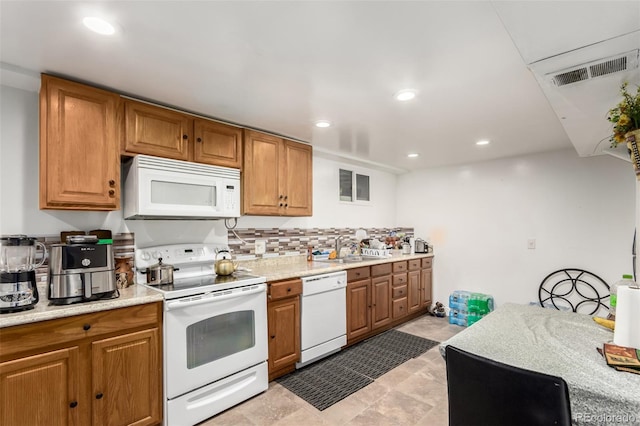 kitchen featuring light stone counters, white appliances, sink, and tasteful backsplash