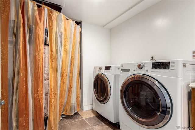 laundry area with independent washer and dryer and dark tile patterned flooring