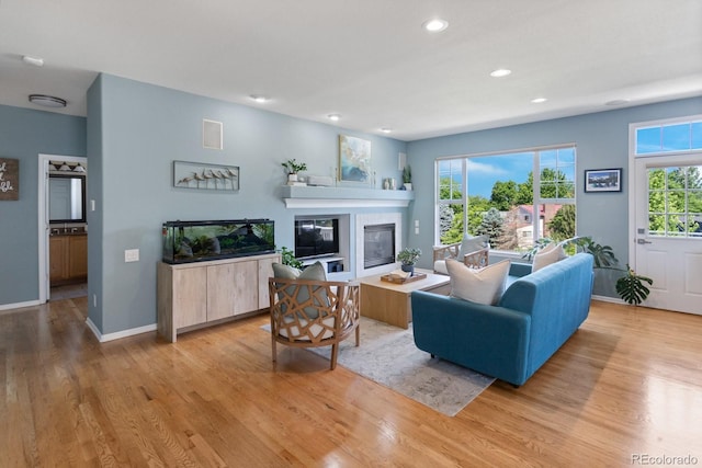 4515 W 107th Cir, Westminster, CO 80031 - living area featuring light wood-style floors, recessed lighting, a glass covered fireplace, and plenty of natural light