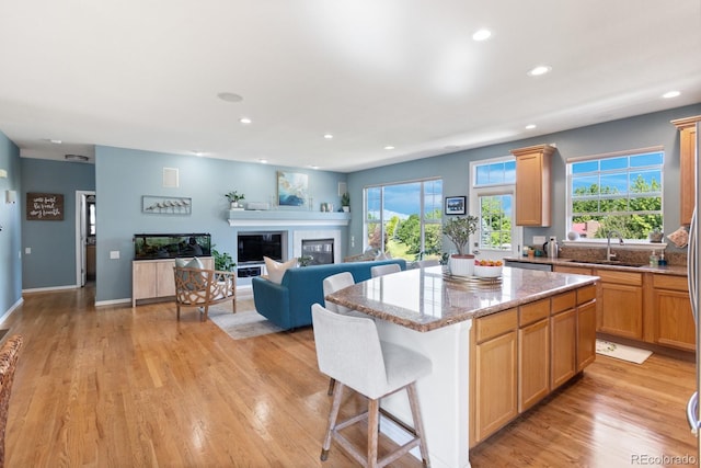 4515 W 107th Cir, Westminster, CO 80031 - kitchen featuring light wood finished floors, recessed lighting, a kitchen island, healthy amount of natural light, and a breakfast bar area
