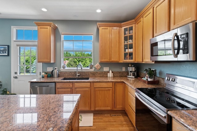 4515 W 107th Cir, Westminster, CO 80031 - kitchen with stainless steel appliances, light wood finished floors, glass insert cabinets, light stone counters, and recessed lighting