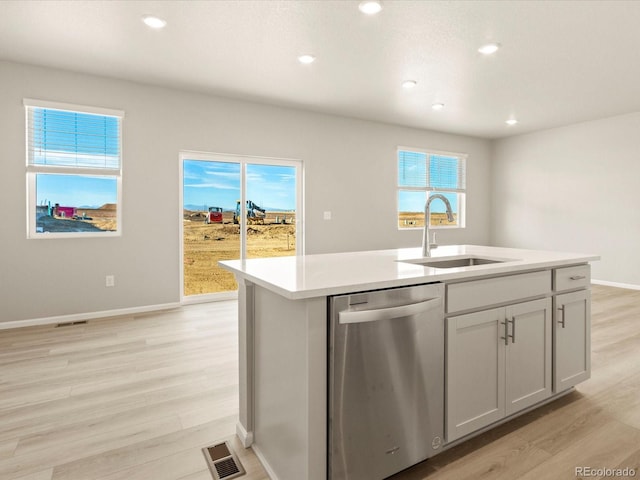 kitchen featuring light hardwood / wood-style floors, sink, dishwasher, and an island with sink