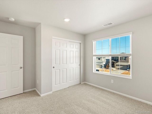 unfurnished bedroom featuring carpet and a closet