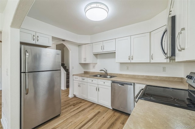 kitchen featuring white cabinets, light hardwood / wood-style floors, sink, and stainless steel appliances