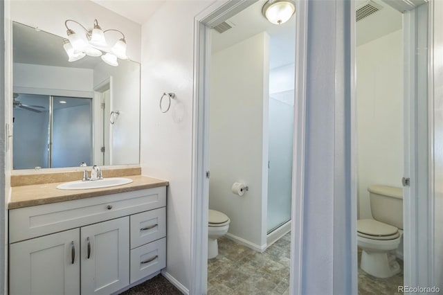 bathroom with a shower with door, vanity, and toilet