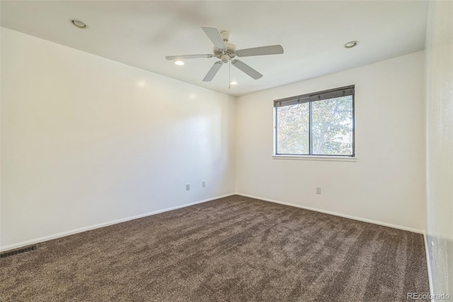 carpeted spare room featuring ceiling fan