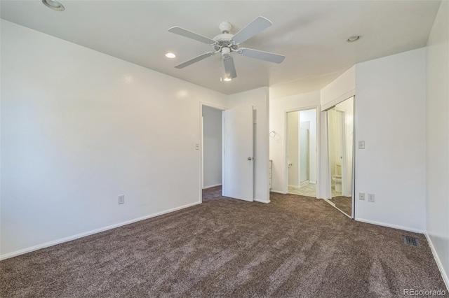 unfurnished bedroom with ceiling fan and dark carpet