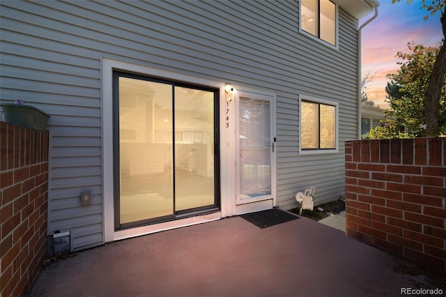 exterior entry at dusk featuring a patio area