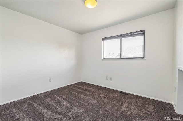 unfurnished room featuring dark carpet