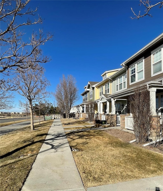 view of side of property with a residential view and a lawn