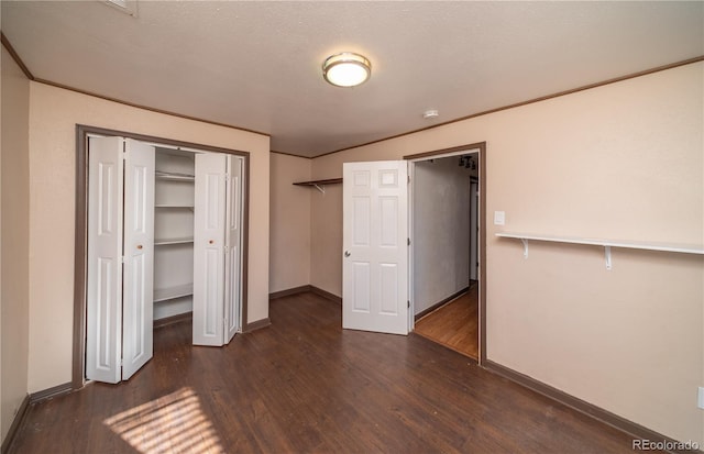 unfurnished bedroom with a textured ceiling and dark wood-type flooring