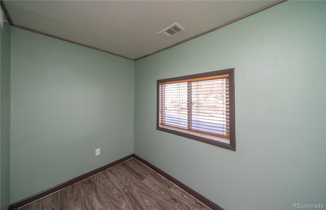 empty room with wood-type flooring and a textured ceiling