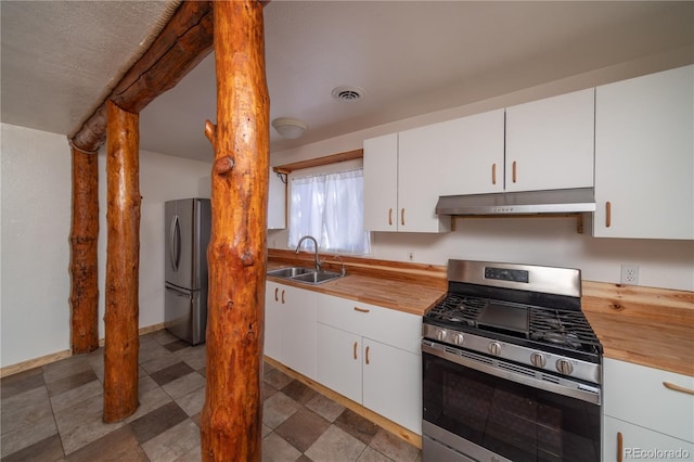 kitchen with butcher block countertops, sink, white cabinets, and appliances with stainless steel finishes