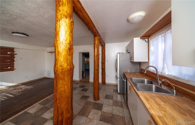 kitchen featuring white cabinets, a textured ceiling, dark wood-type flooring, and sink