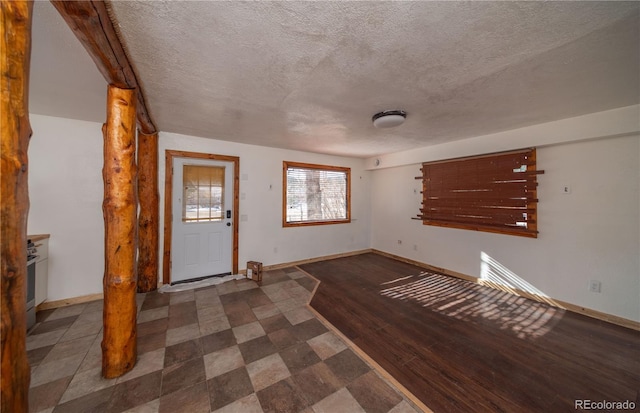 entryway with dark hardwood / wood-style flooring and a textured ceiling