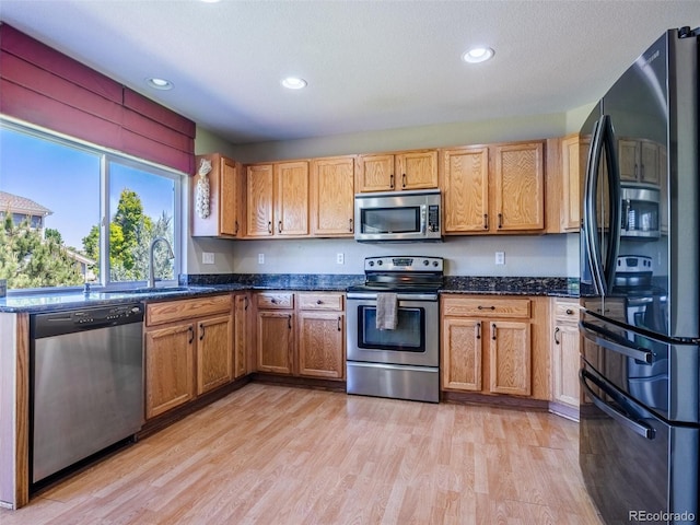 5369 Creek Way, Parker, CO 80134 - kitchen featuring appliances with stainless steel finishes, a sink, light wood finished floors, recessed lighting, and dark stone countertops