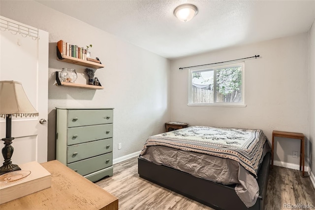 bedroom with wood finished floors and baseboards