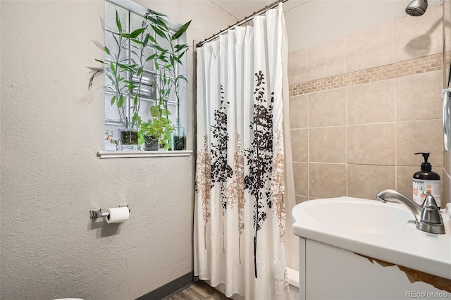 full bathroom with a shower with curtain, wood finished floors, and a sink