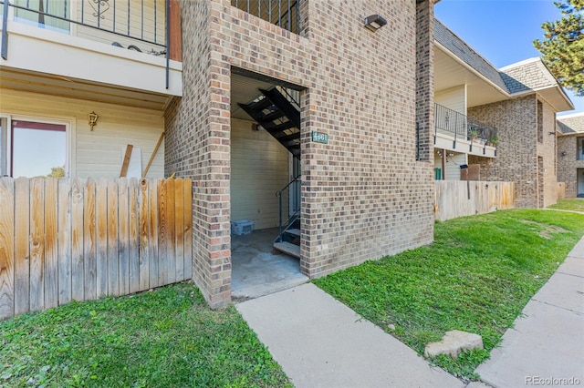 doorway to property with a yard and a balcony