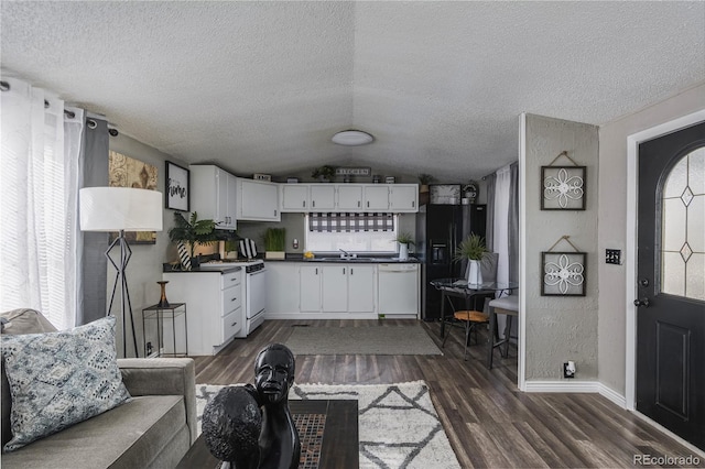 890 S Cellini Plz, Pueblo West, CO 81007 - kitchen featuring white appliances, dark countertops, a sink, a textured ceiling, and dark wood finished floors