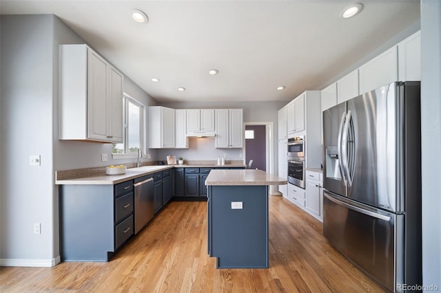 20339 Vista Cir, Parker, CO 80138 - kitchen with appliances with stainless steel finishes, a center island, light wood-style floors, light countertops, and under cabinet range hood