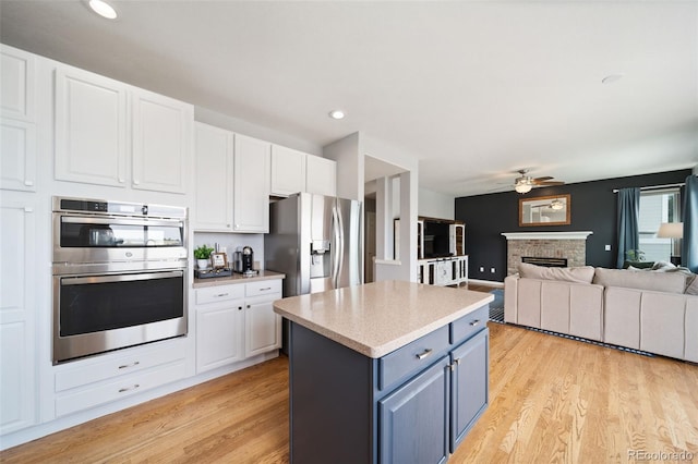 20339 Vista Cir, Parker, CO 80138 - kitchen with appliances with stainless steel finishes, ceiling fan, white cabinetry, a kitchen island, and recessed lighting