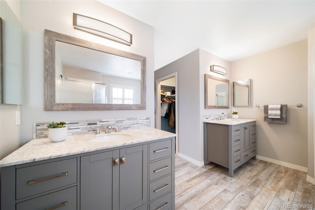 20339 Vista Cir, Parker, CO 80138 - full bathroom with wood finished floors, two vanities, a shower with door, a spacious closet, and backsplash