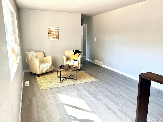 living area with hardwood / wood-style flooring and plenty of natural light