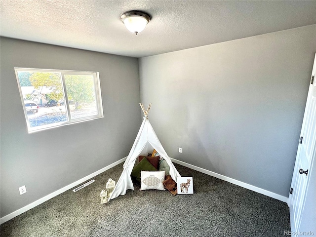 rec room featuring a textured ceiling and carpet floors